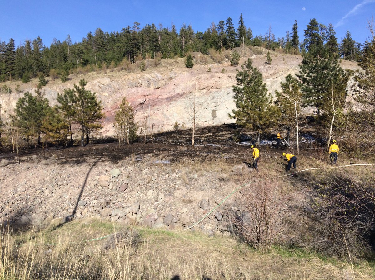 Crews continue to douse hot spots following a brush fire Wednesday afternoon between West Kelowna and Peachland. 
