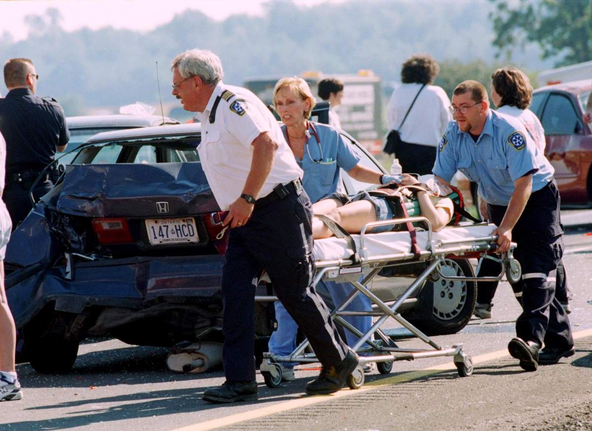 Ambulance paramedics transport a victim to hospital following a multi-vehicle pileup involving more that 60 vehicles near Windsor, Ont. Friday, Sept. 3, 1999.