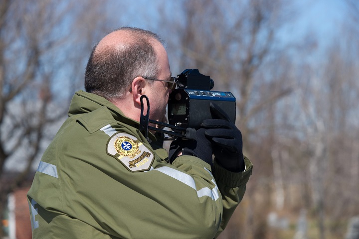 In this file photo, a Sûreté du Quebec officer is checking motorists' speed on the highway with a radar gun. In total, 22,143 tickets were handed out for infractions to Quebec's Highway Safety Code during the annual construction holiday from July 17 to Aug. 2, 2020.