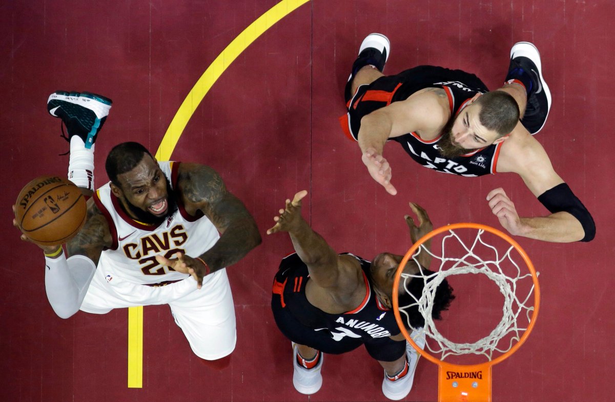 Cleveland Cavaliers' LeBron James shoots as Toronto Raptors' OG Anunoby and Jonas Valanciunas, right, defend during the first half of an NBA basketball game Tuesday, April 3, 2018, in Cleveland. 