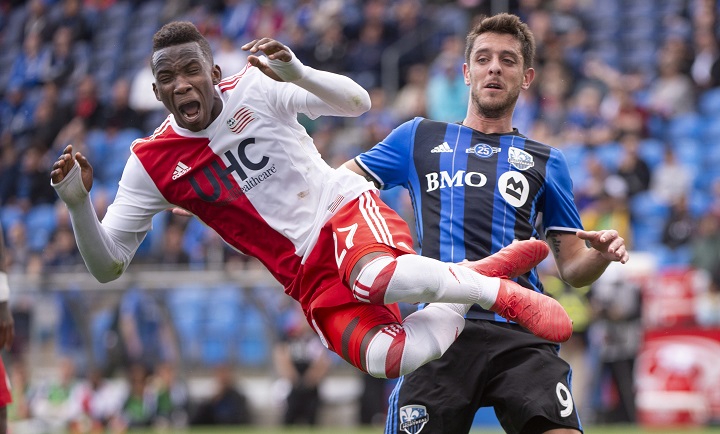 New England Revolution's Luis Caicedo leaps into the air after kicking the ball away from Montreal Impact midfielder Alejandro Silva during second half MLS action Saturday, May 5, 2018 in Montreal. 