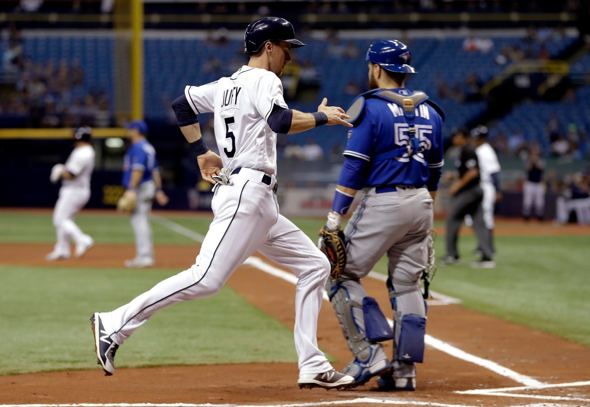 Tampa Bay Rays' Matt Duffy (5) scores behind Toronto Blue Jays catcher Russell Martin on an error by second baseman Lourdes Gurriel Jr. during the first inning of a baseball game Saturday, May 5, 2018, in St. Petersburg, Fla.