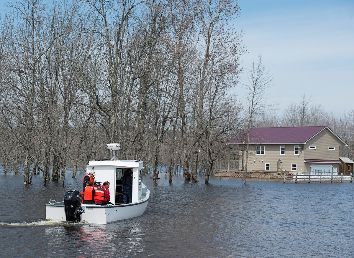 A boat ferries residents to Darlings Island, N.B., cut off by flood waters, on Sunday, May 6, 2018. 