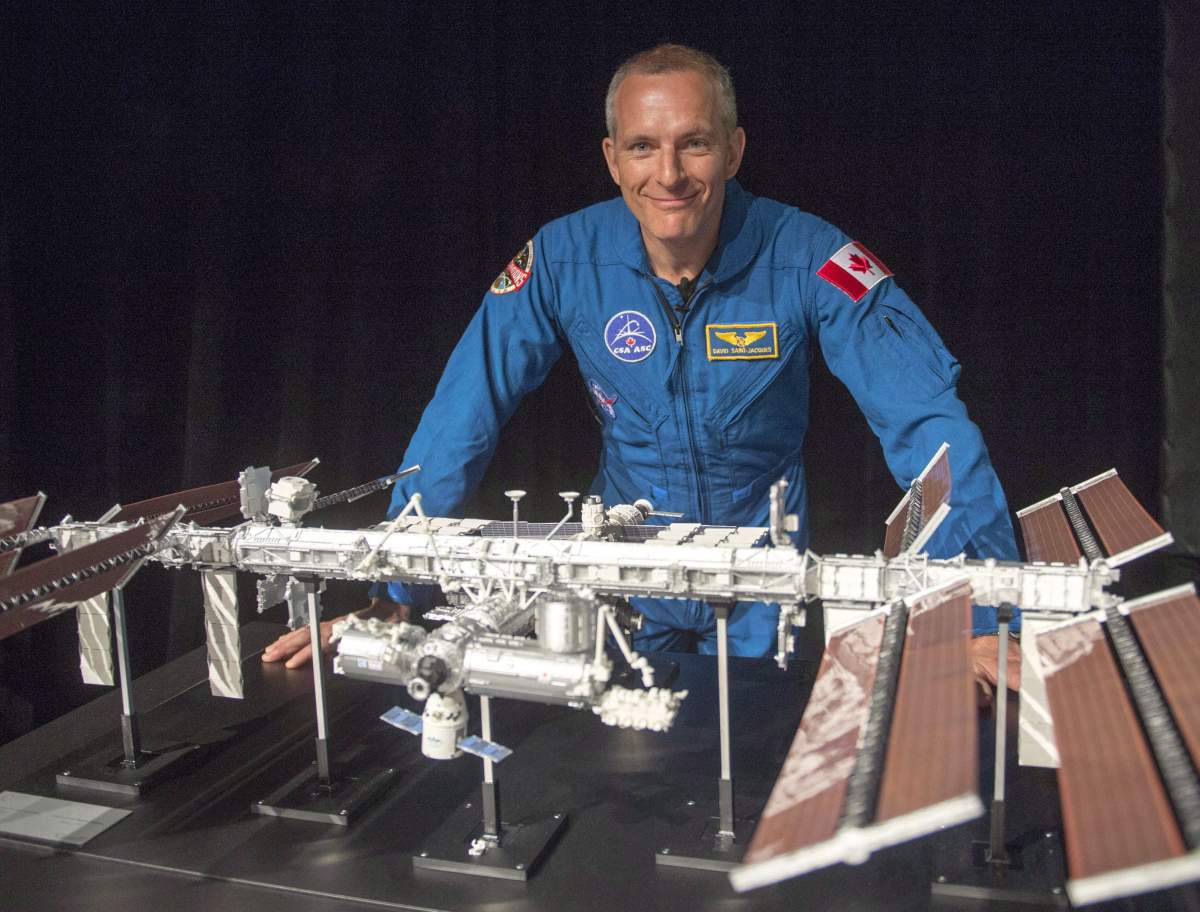 Canadian astronaut David Saint-Jacques looks at a model of the International Space Station at the Canadian Space Agency headquarters in Saint Hubert, Que. on Wednesday, November 29, 2017. Smoked salmon, shrimp cocktails, pate, chocolate fondue and maple syrup are all headed for space.Those tasty foods will be part of David Saint-Jacques' menu during the Canadian astronaut's upcoming six-month stay on the International Space Station. 