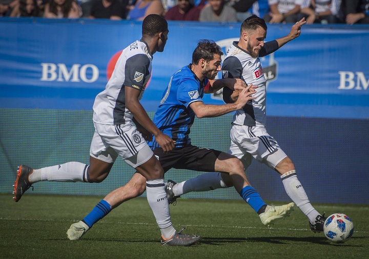 Montreal Impact's Ignacio Piatti, centre, tries to get between two Philadelphia Union players during second half MLS action in Montreal on Saturday, May 12, 2018.