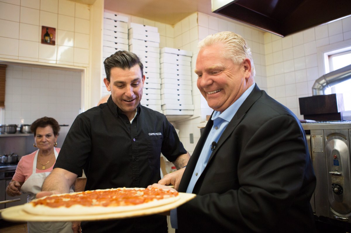 Ontario PC leader Doug Ford helps bake pizzas before an announcement at Capri Pizza during a campaign stop in Cambridge, Ont., on Thursday.