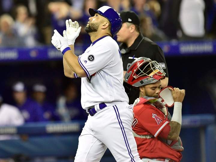 Toronto Blue Jays designated hitter Kendrys Morales (8) celebrates after hitting a two-run home run against Los Angeles Angels starting pitcher Garrett Richards scoring Jays Russell Martin in first inning American League baseball action in Toronto on Tuesday.