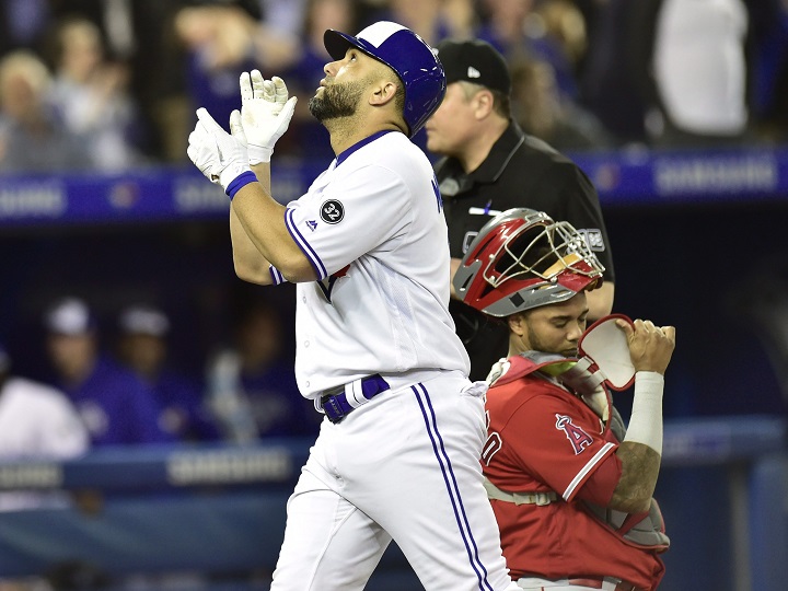Toronto Blue Jays designated hitter Kendrys Morales (8) celebrates after hitting a two-run home run against Los Angeles Angels starting pitcher Garrett Richards scoring Jays Russell Martin in first inning American League baseball action in Toronto on Tuesday.