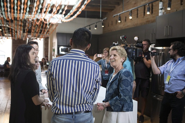Ontario Liberal Leader Kathleen Wynne talks to employees during a campaign stop at Wattpad's offices to make an announcement in Toronto on Thursday.