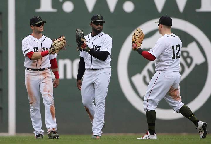 Boston Red Sox outfielders, from left to right, Andrew Benintendi, Jackie Bradley Jr. and Brock Holt celebrate after they defeated the Toronto Blue Jays in a baseball game at Fenway Park, Monday, May 28, 2018, in Boston.