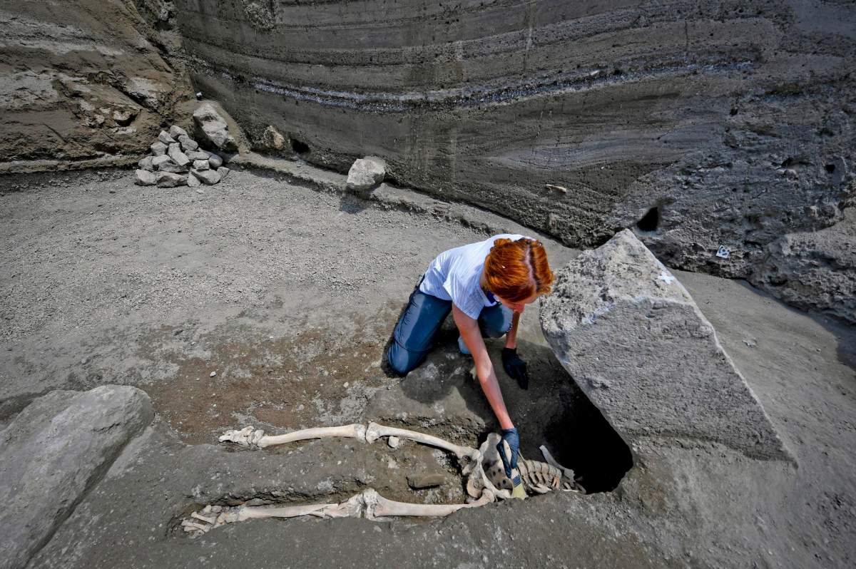 Anthropologist Valeria Amoretti works with a brush on a skeleton of a victim of the eruption of Mt. Vesuvius in A.D. 79, which destroyed the ancient town of Pompeii.