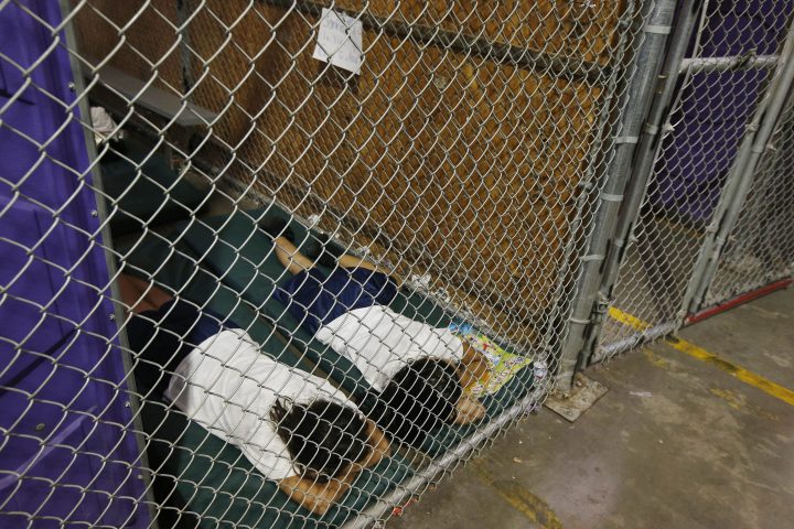 In this June 18, 2014 file photo, two female detainees sleep in a holding cell, as the children are separated by age group and gender, as hundreds of mostly Central American immigrant children are being processed and held at the U.S. Customs and Border Protection Nogales Placement Center in Nogales, Ariz.