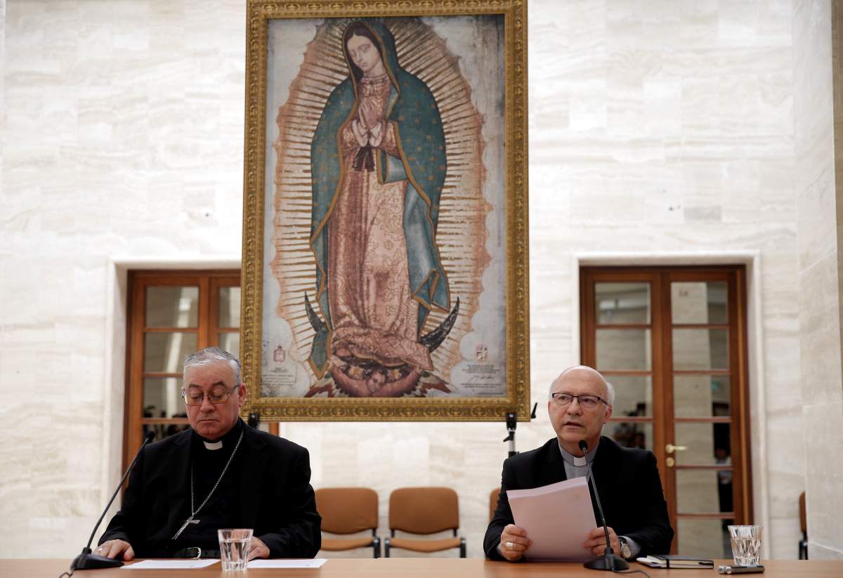 Chilean bishops Luis Fernando Ramos Perez and Juan Ignacio Gonzalez Errazuriz read statements during a news conference after a meeting with Pope Francis at the Vatican, May 18, 2018. 
