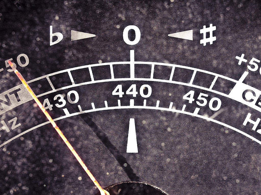 A vintage plastic guitar tuner measures 440 Hz.