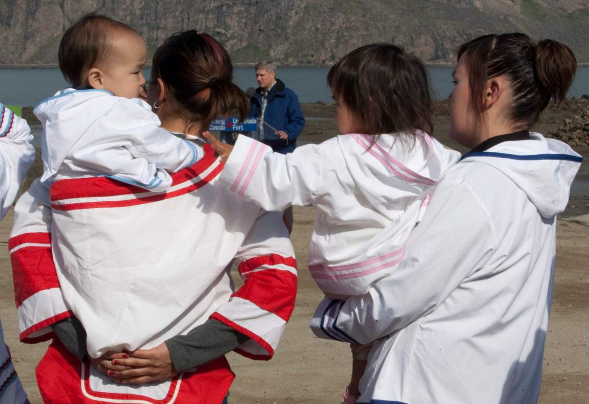 Local women look after young children as Prime Minister Stephen Harper makes an announcement in Pangnirtung, Nunavut Thursday, Aug. 20, 2009.   