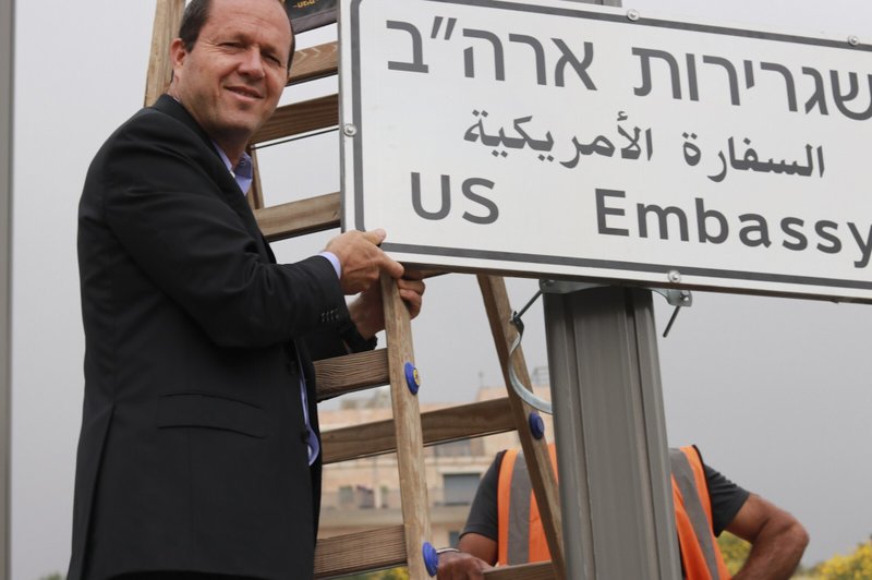 In this photo released by the Jerusalem Municipality, Jerusalem mayor Nir Barkat poses with a new road sign to the new U.S. Embassy in Jerusalem, Monday, May 7, 2018. 