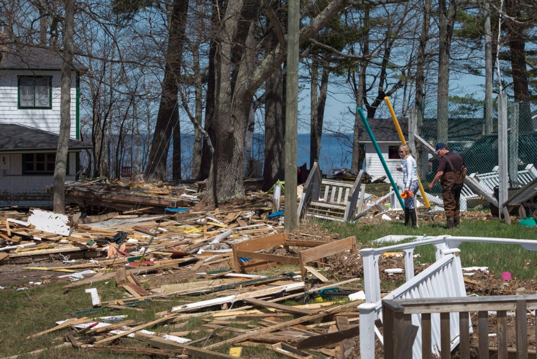 Michelle and Leo Cain look for belongings in debris from homes and cottages destroyed by the floodwater from the Saint John River in Robertson’s Point, N.B., on Sunday, May 13, 2018. THE CANADIAN PRESS/Darren Calabrese