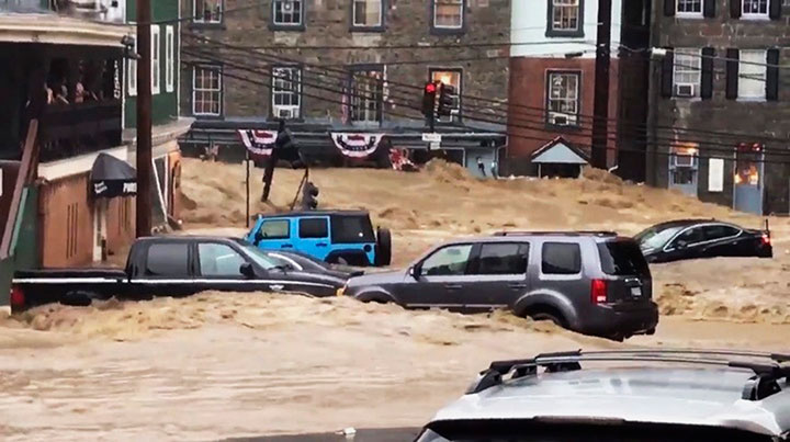 Water rushes through Main Street in Ellicott City, Md., Sunday, May 27, 2018.