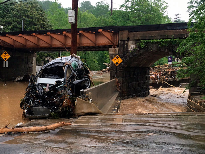 A damaged vehicle swept away by floodwaters stopped by a utility pole in Ellicott City, Md., Sunday, May 27, 2018.