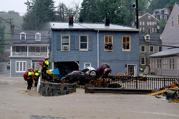 Rescuers work to free people trapped upstairs at a record store during torrential rain that caused flash floods along Main Street May 27, 2018 in Ellicott City, MD.