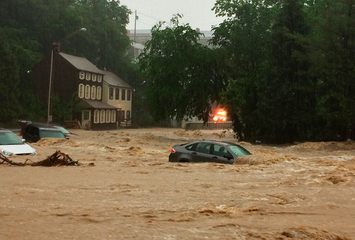 Water rushes through Main Street in Ellicott City, Md., Sunday, May 27, 2018.