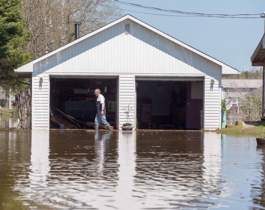 Rick Banks walks past his garage while cleaning up debris from his property located along route 105 in Maugerville, N.B, Wednesday, May 9, 2018. For many residents of the riverside communities of New Brunswick, the long and stressful process of cleaning up damaged properties is underway in the wake of a record-breaking flood.