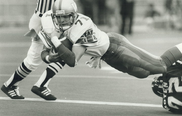 Winnipeg Blue Bomber Joe Poplawski cradles the ball in his arms as he dives over the Toronto Argonauts goal line to score a touchdown during a CFL game at Exhibition Stadium.