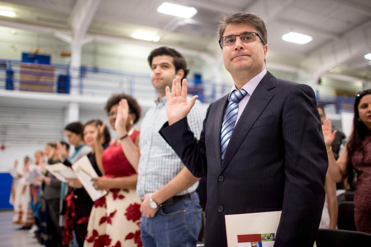 New Canadians take the oath of citizenship during a citizenship ceremony held at the Royal Canadian Navy local reserve division HMCS York.