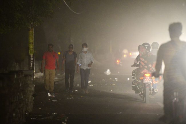 People cover themselves as they walk beside a road during a dust storm in Allahabad, India on May 13, 2018. 


