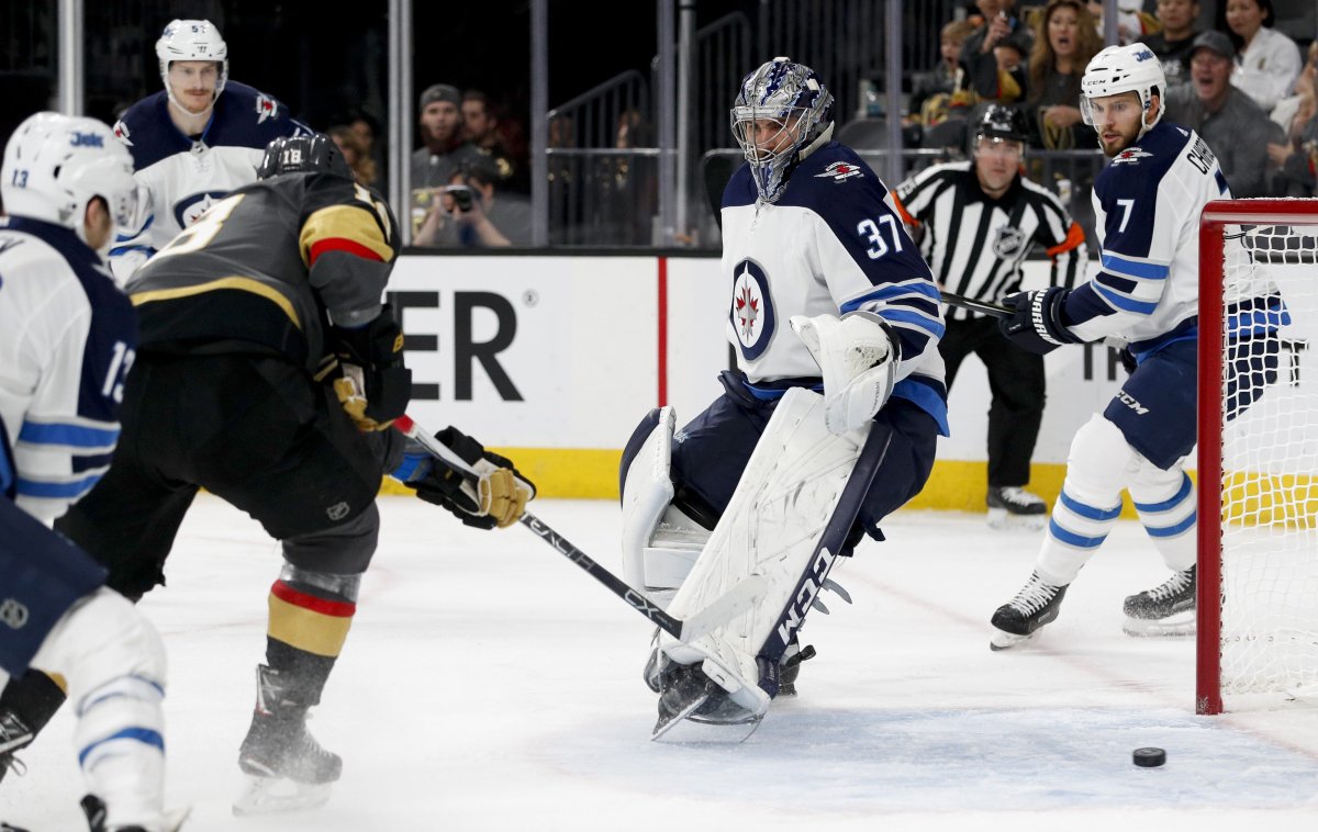 Vegas Golden Knights left wing James Neal, left, scores past Winnipeg Jets goaltender Connor Hellebuyck during the second period of Game 3 of the NHL hockey playoffs Western Conference finals Wednesday, May 16, 2018, in Las Vegas. 