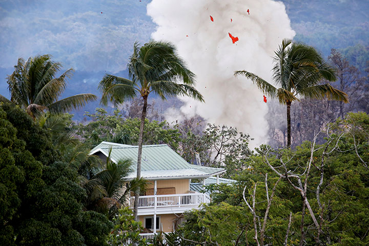 Smoke and lava erupt from a fissure near a home on the outskirts of Pahoa during ongoing eruptions of the Kilauea Volcano in Hawaii, May 14, 2018.