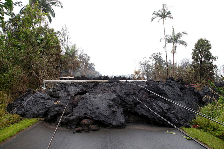 Lava and downed power lines block a road in the Leilani Estates subdivision during ongoing eruptions of the Kilauea Volcano, Hawaii, May 8, 2018.