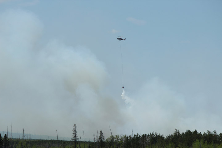 An aerial unit drops water on a wildfire burning out of control near Holbein, Sask., on May 15, 2018.