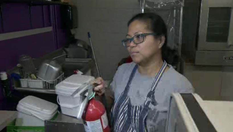 Lorie Jimenez lifts up fire extinguisher used to help a man who was on fire in Victoria. 