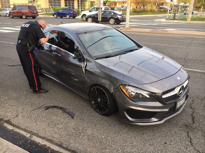 A Toronto police officer can be seen examining a vehicle after a pursuit in Scarborough on Tuesday evening.