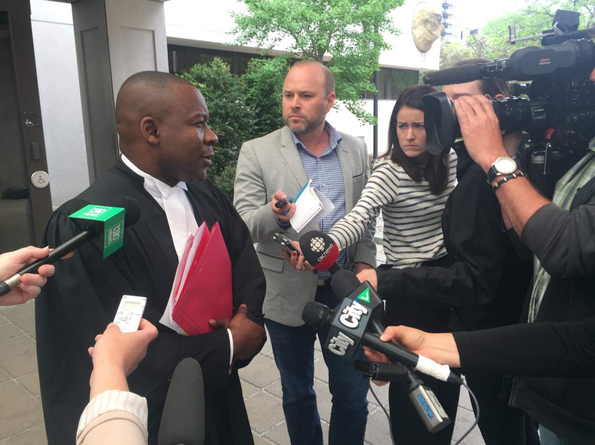 Hikoalok's lawyer speaks to reporters after his initial appearance in court Monday.