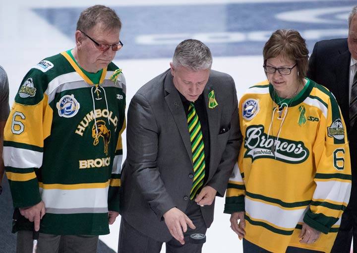 Humboldt Broncos president Kevin Garinger, centre, and team athletic therapist Dayna Brons's mom Carol Brons as dad Lyle take part in a ceremonial puck drop.