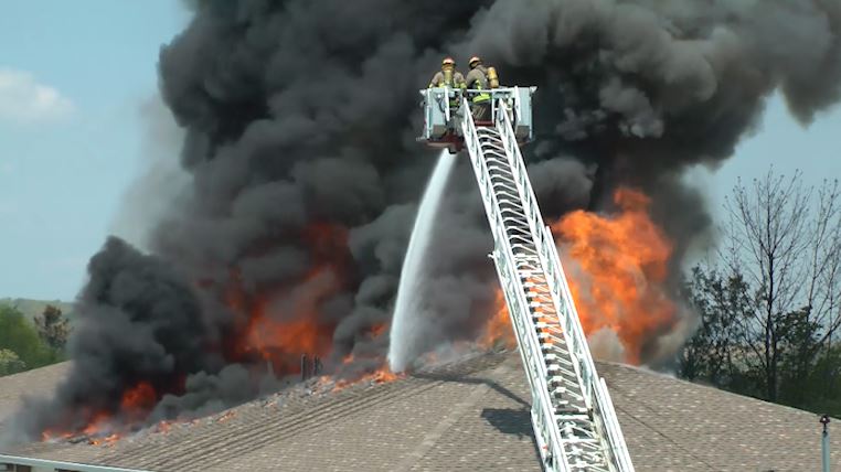 Port Hope firefighters pour water on the roof of an apartment fire on Thursday .