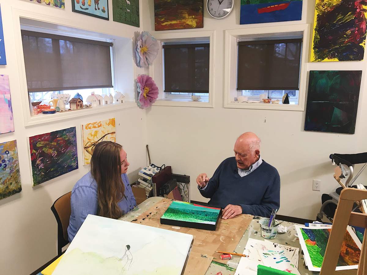 Student and senior share time in the residence\’s art studio