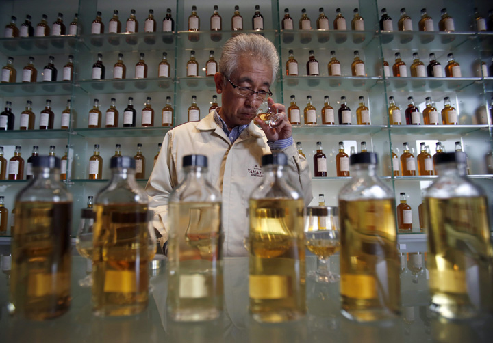 In this March 8, 2017 photo, Suntory’s chief blender Shinji Fukuyo demonstrates how he examines the whisky at the Suntory distillery in Yamazaki, near Kyoto, western Japan.