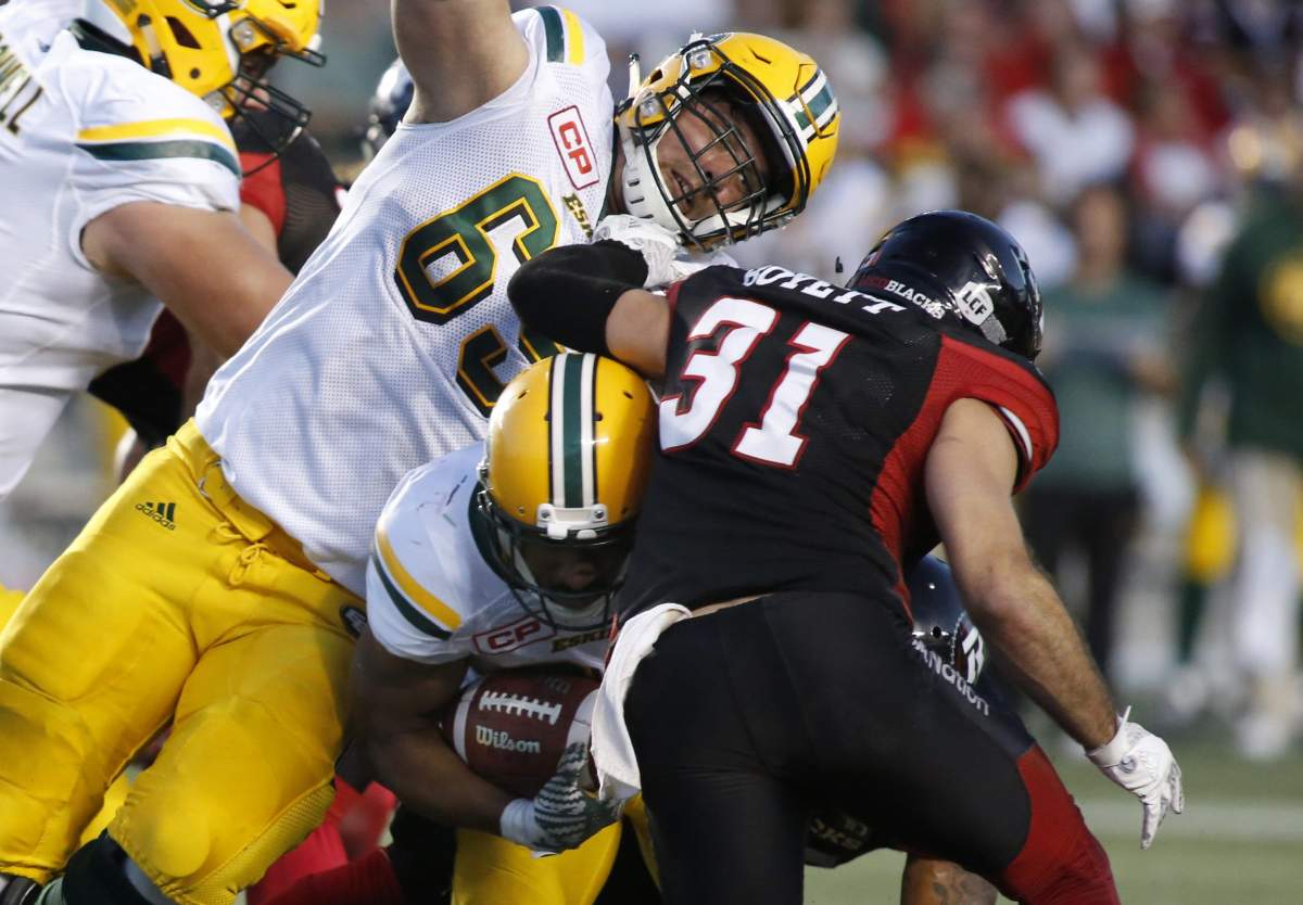 The Edmonton Eskimos John White tries to squeeze between the Edmonton Eskimos Simeon Rottier and the Ottawa Redblacks John Boyett during second quarter CFL action in Ottawa on Saturday, August 6, 2016.  