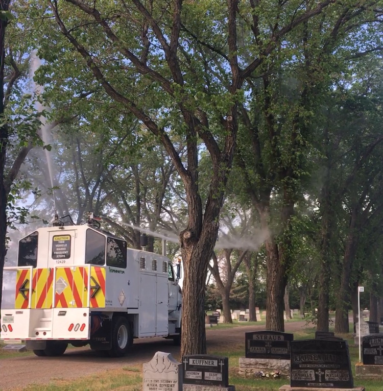 "The Worminator" sprays trees in the Regina Cemetery.