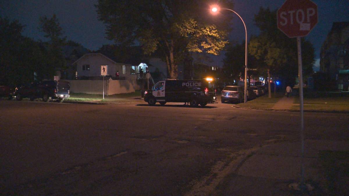 A police vehicle blocks the street where officers negotiate with a man holed up inside a nearby building.