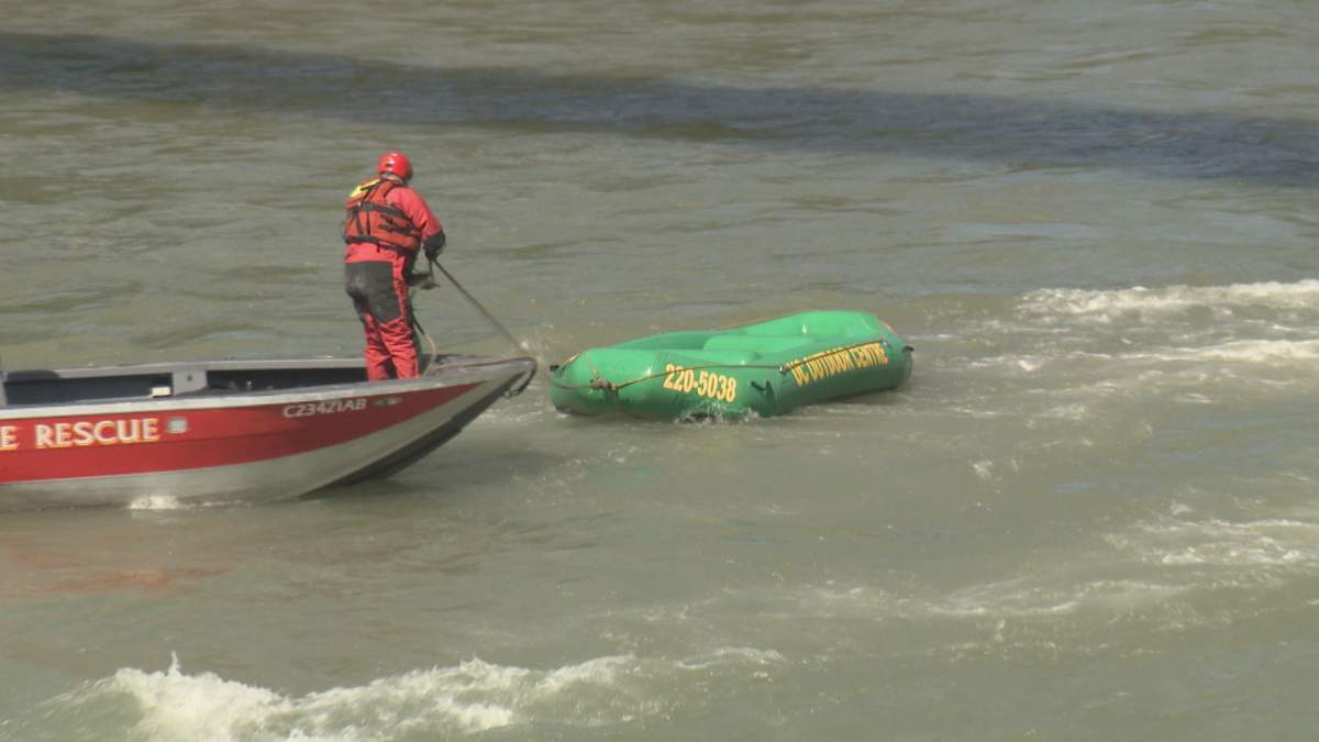 Firefighters retrieve a raft from the Bow River.