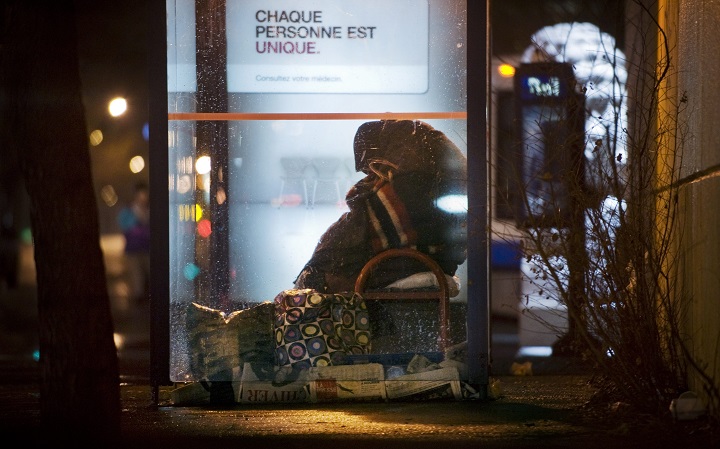 In this file photo, a homeless person takes refuge in a bus shelter in Montreal.