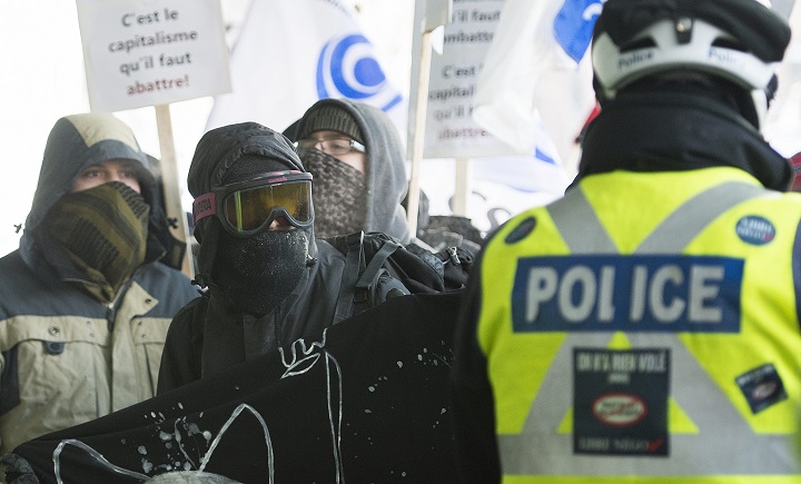 In this file photo, masked protesters confront police during an anti austerity demonstration in Montreal, Tuesday, February 3, 2015. During a recent meeting of Montreal's police oversight body, Insp. Pascal Richard revealed city police officers dressed in civilian clothing and wearing masks would infiltrate protests pretending to be protesters. Thursday, June 28, 2018.