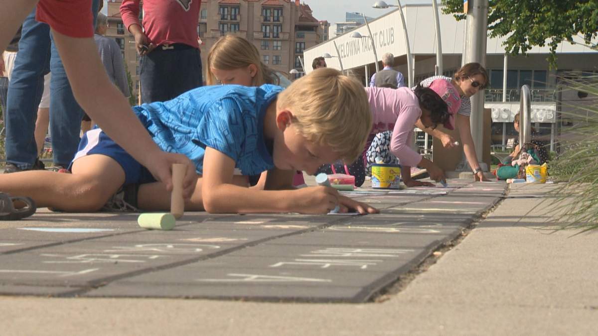 Kids writing inspirational messages along Kelowna's waterfront Thursday evening. 