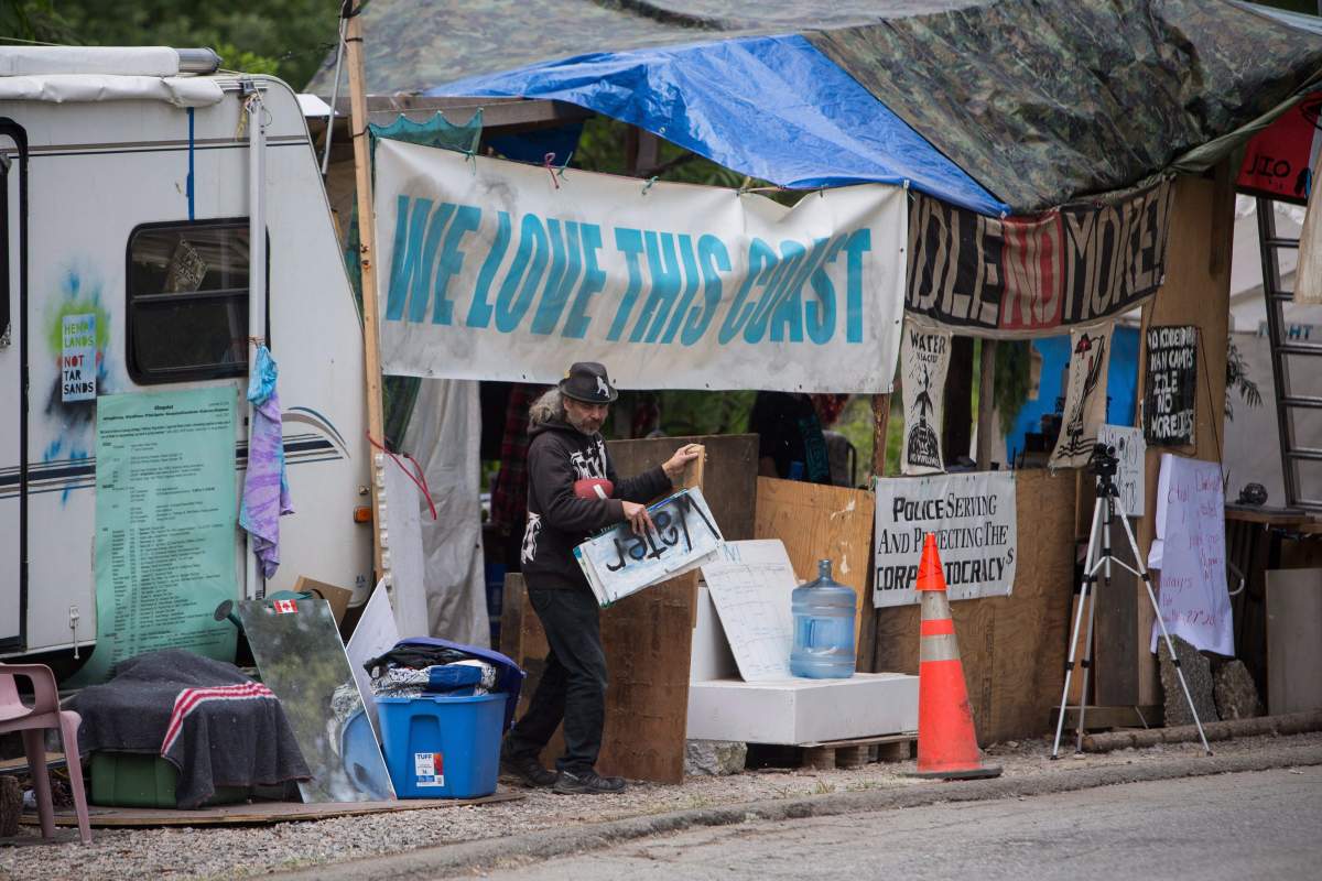 A protester is pictured outside of a demonstration camp set up outside the front gates of Kinder Morgan’s Trans Canada pipeline terminal on Burnaby Mountain in Burnaby, B.C., on May 29, 2018.