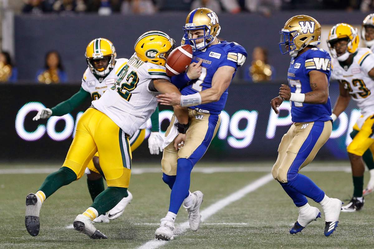 Winnipeg Blue Bombers quarterback Chris Streveler (17) fumbles the ball after getting hit by Edmonton Eskimos' Brandon Pittman (92) during the second half of pre-season CFL action in Winnipeg Friday, June 1, 2018. 