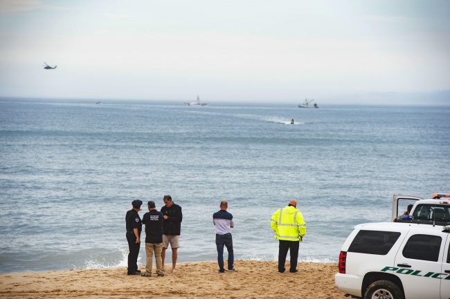 Members of the New York State park police look near the scene of a plane crash in the ocean off Indian Wells Beach in Amagansett, N.Y.,June 2, 2018. 
